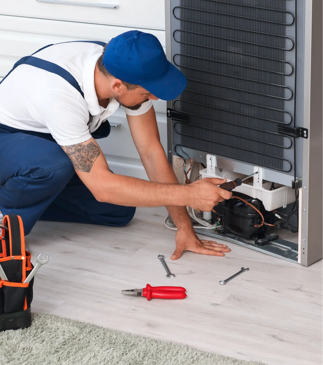 A man fixing a freezer.
